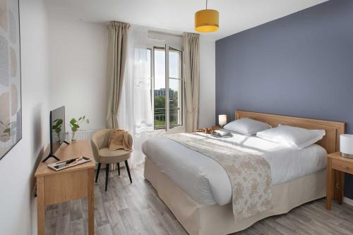 a bedroom with a bed and a desk and a window at Domitys Le 225 in Levallois-Perret