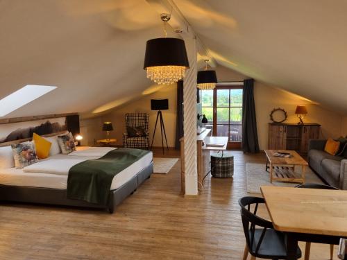 ein Schlafzimmer mit einem Bett und ein Wohnzimmer in der Unterkunft Gasthof Chiemseefischer in Grabenstätt