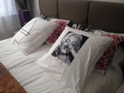 a bed with a picture of a woman on the pillows at Chambres et Table d'hôtes La Belle Lensoise in Lens