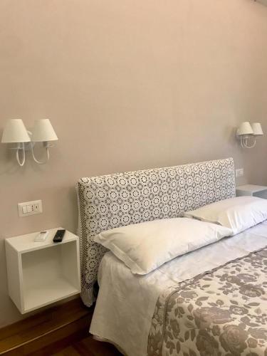 a bedroom with a bed and two lamps on the wall at B&B I Due Teatri in Naples
