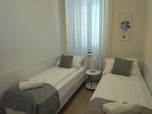 Camera piccola con 2 letti e un tavolo di Apartments B&M a Sežana