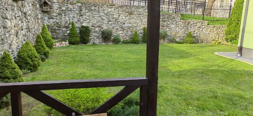 a bench sitting in a yard with a stone wall at Apartament JOANNA in Sanok