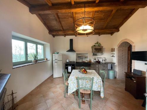 cocina con mesa con sillas y comedor en Val D’Orcia Eco Cottage, en Campiglia dʼOrcia