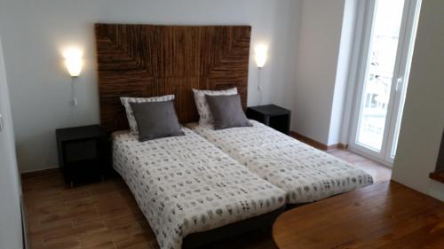 1 dormitorio con 1 cama grande y cabecero de madera en Rossio Studios, en Lisboa