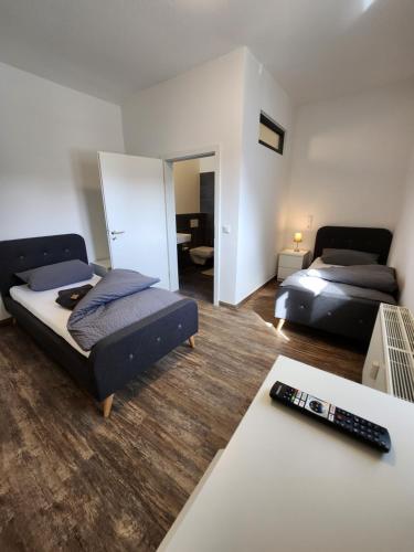 een woonkamer met 2 bedden en een afstandsbediening bij Monteurzimmer in Bielefeld - Mitte in Bielefeld