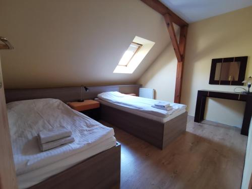 a small room with two beds and a sink at Hotel Zieliniec in Poznań