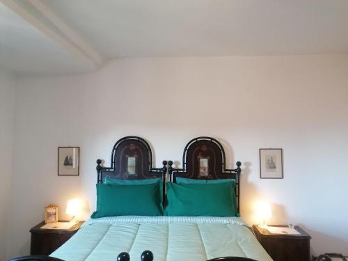 een slaapkamer met een groot bed met groene kussens bij Residenza Le Ortensie in Todi