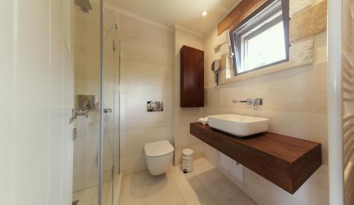 baño con lavabo y aseo y ventana en Villa Kalamos / Sea View and Pool nearby Athens en Kálamos