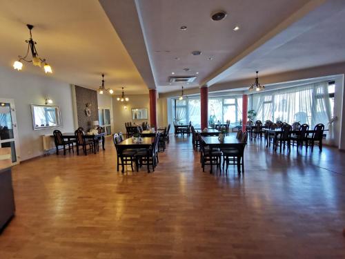 un comedor con mesas y sillas en un restaurante en Hotel Zieliniec en Poznan