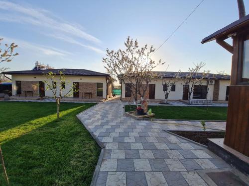 a house with a walkway in front of a yard at CAMERE de INCHIRIAT CRIS&DIA in Eforie Sud