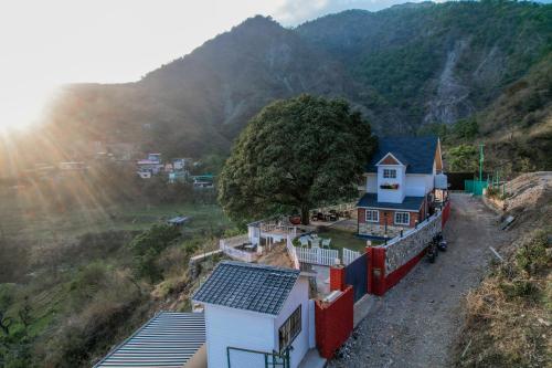 a house with solar panels on the side of a hill at SaffronStays Woodpeckers Perch Villa, Dehradun in Rājpur