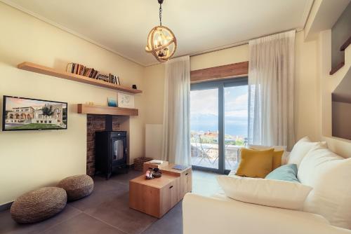 un soggiorno con divano bianco e camino di Villa Kalamos / Sea View and Pool nearby Athens a Kalamos