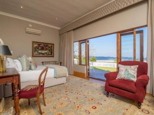 a bedroom with a bed and a desk and a chair at Issaquena Heights Boutique Hotel in Knysna