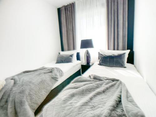 two beds sitting next to each other in a room at M-Style 02 Apartment mit Balkon 24h Self-Check-In, Free Parking, Netflix in Nürnberg