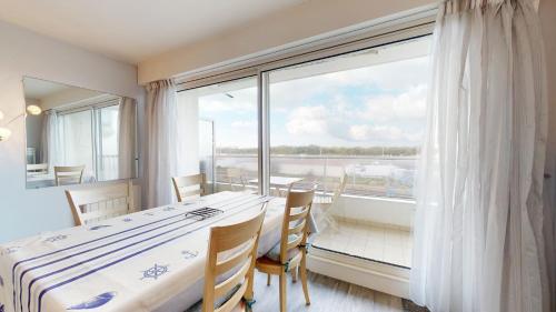 - une chambre avec une table et une grande fenêtre dans l'établissement La Cabine du Capitaine, à Saint-Gilles-Croix-de-Vie