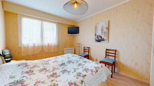 - une chambre avec un lit, deux chaises et une télévision dans l'établissement La Cabine du Capitaine, à Saint-Gilles-Croix-de-Vie