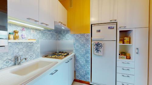 une cuisine avec un évier et un réfrigérateur blanc dans l'établissement La Cabine du Capitaine, à Saint-Gilles-Croix-de-Vie