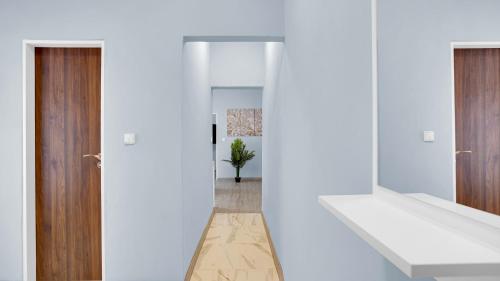 korytarz z białymi ścianami i drewnianymi drzwiami w obiekcie Aphrodite Suite Hotel Karlovy Vary w Karlowych Warach