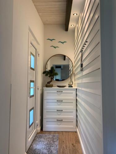 ein Badezimmer mit einer weißen Kommode und einem Spiegel in der Unterkunft Am Dachsberg in Bad Saarow
