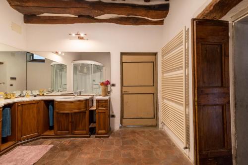 ein großes Bad mit einem Waschbecken und einem Spiegel in der Unterkunft Altrove in Laterina