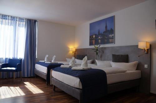 una habitación de hotel con 2 camas y una silla en Appartementhaus Beckergrube, en Lübeck