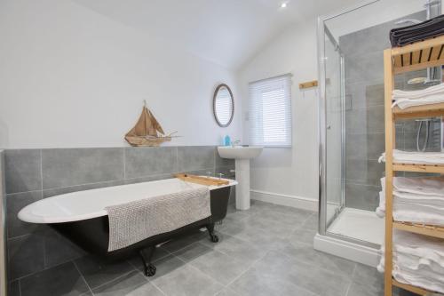 a bathroom with a bath tub and a shower at 5 Bedroom Family Retreat Exmouth, Devon in Exmouth