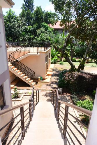 a stairway leading up to a building with trees at Golden Cherries Guest House in Jinja