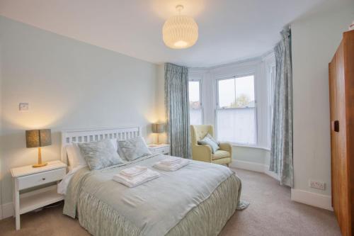 ein Schlafzimmer mit einem Bett, einem Stuhl und einem Fenster in der Unterkunft 5 Bedroom Family Retreat Exmouth, Devon in Exmouth