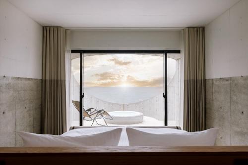 um quarto com uma janela com vista para o oceano em Izumo HOTEL THE CLIFF 