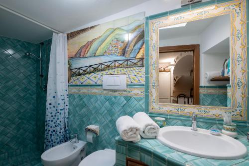 y baño con lavabo y espejo. en Il Paridà, en Amalfi