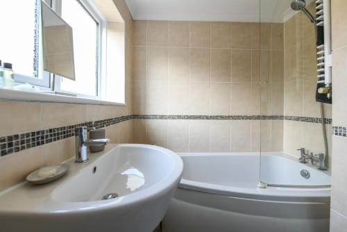 a bathroom with a tub and a toilet and a sink at The Colebrook in Royal Tunbridge Wells