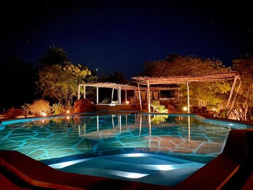 a swimming pool at night with a gazebo at Rock and Sea Resort in Watamu