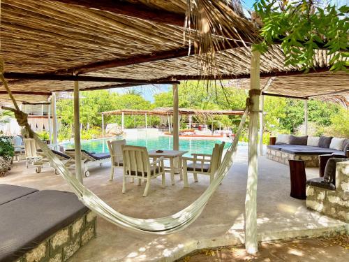 a hammock on a patio next to a pool at Rock and Sea Resort in Watamu