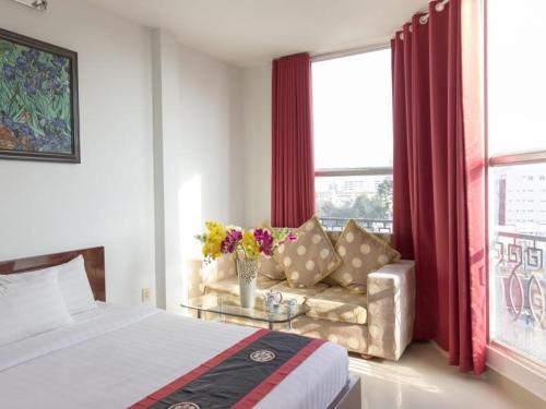 una camera con letto, divano e finestra di Meraki Hotel ad Ho Chi Minh