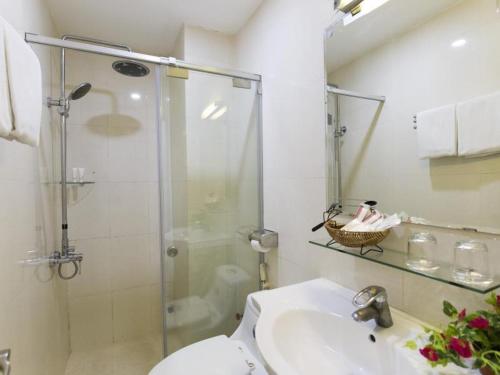 a bathroom with a shower and a sink and a toilet at Meraki Hotel in Ho Chi Minh City