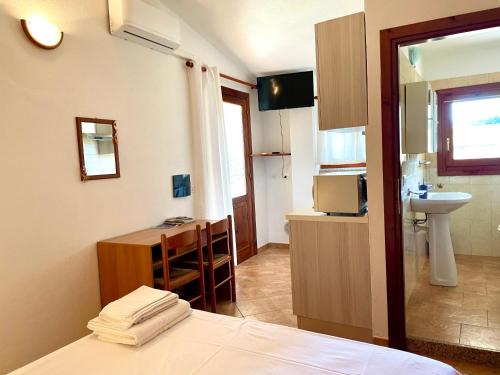 a room with a bed and a sink and a kitchen at Monolocale Italia in Tergu