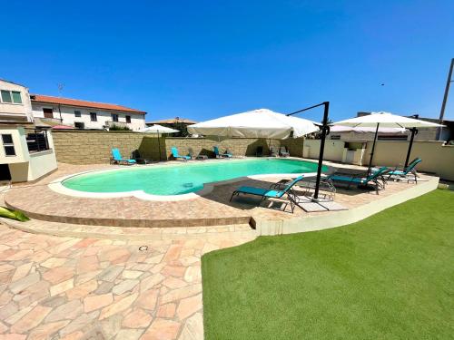a swimming pool with two chairs and umbrellas at Monolocale Italia in Tergu