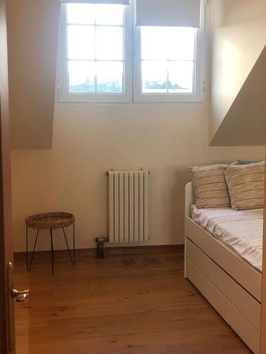 a bedroom with a bed and two windows and a table at Vistas de La Barquera in San Vicente de la Barquera