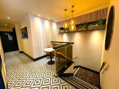 a hallway with stairs and a table in a building at The Continental Hotel, Derby in Derby