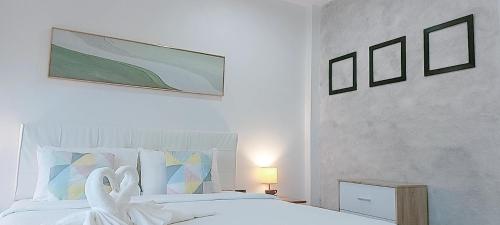 a bedroom with a bed with two swans on it at AINNY Residence in Patong Beach