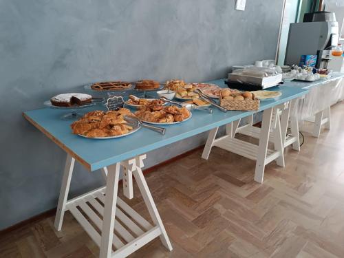 un tavolo con molti tipi diversi di cibo su di esso di Alice Hotel a Cervia