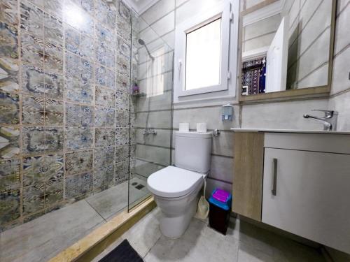 a bathroom with a toilet and a sink and a window at Downtown Sea View Suites in Alexandria