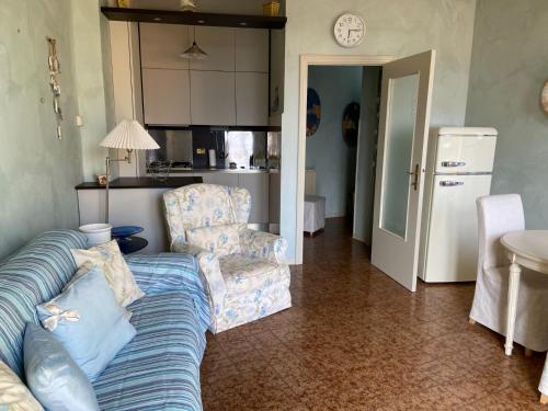 a living room with a couch and chairs and a kitchen at Lola a Moneglia in Moneglia