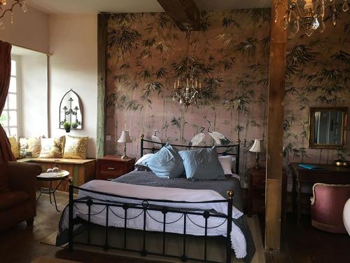 une chambre avec un lit avec un papier peint fleuri dans l'établissement Chateau Gros Puy, Petit Chateau chambre d'hote, à Abjat