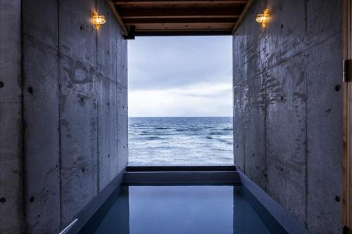 an empty room with a view of the ocean at Izumo HOTEL THE CLIFF in Kumura