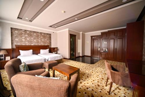 a hotel room with a bed and two chairs at Central Hotel Yerevan in Yerevan