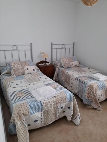 two beds sitting next to each other in a bedroom at Apartamento Playa de Esteiro in Ribadeo