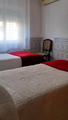 a hotel room with two beds and a window at Casa da Forja in Pinhal Novo
