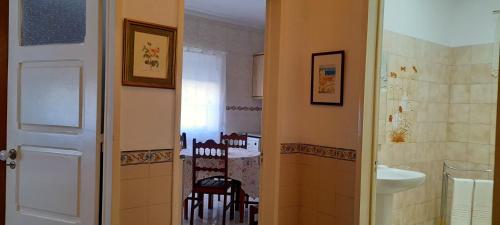 a bathroom with a sink and a kitchen with a table at Casa da Forja in Pinhal Novo