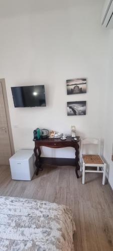 a bedroom with a desk and a tv on the wall at B&B D'AMARE in Cupra Marittima